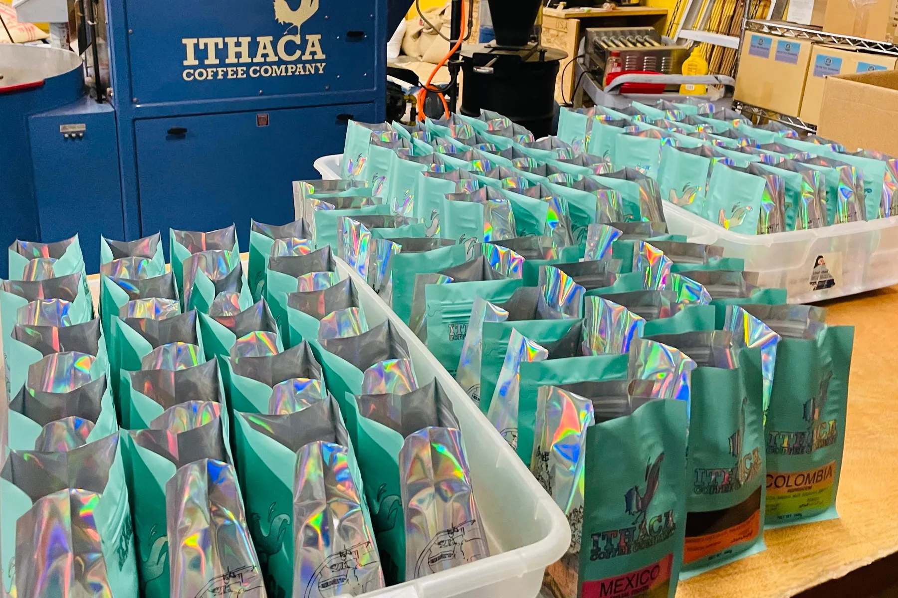 Trays of packed coffee bags beside the roaster
